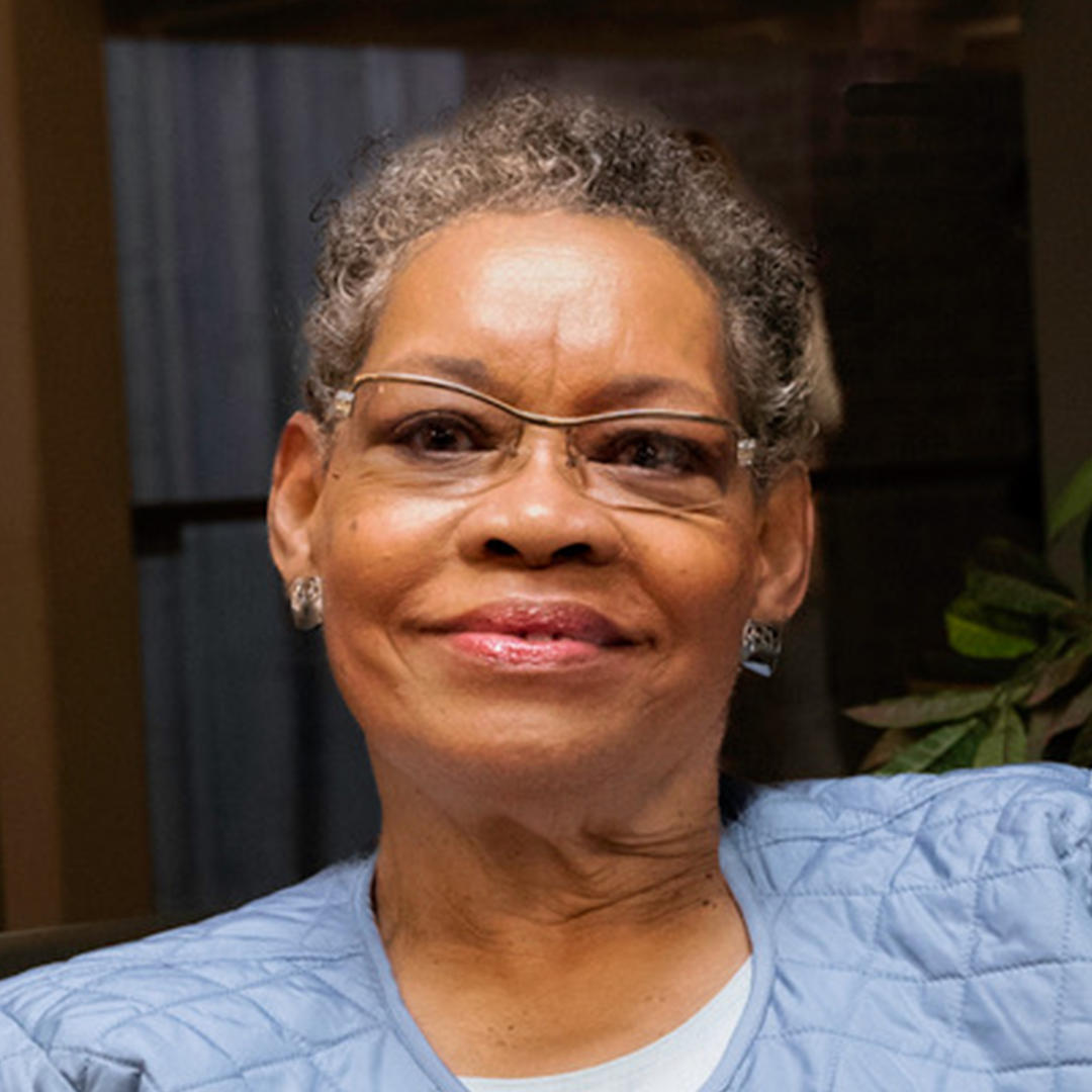 Smiling woman wearing glasses and blue jacket
