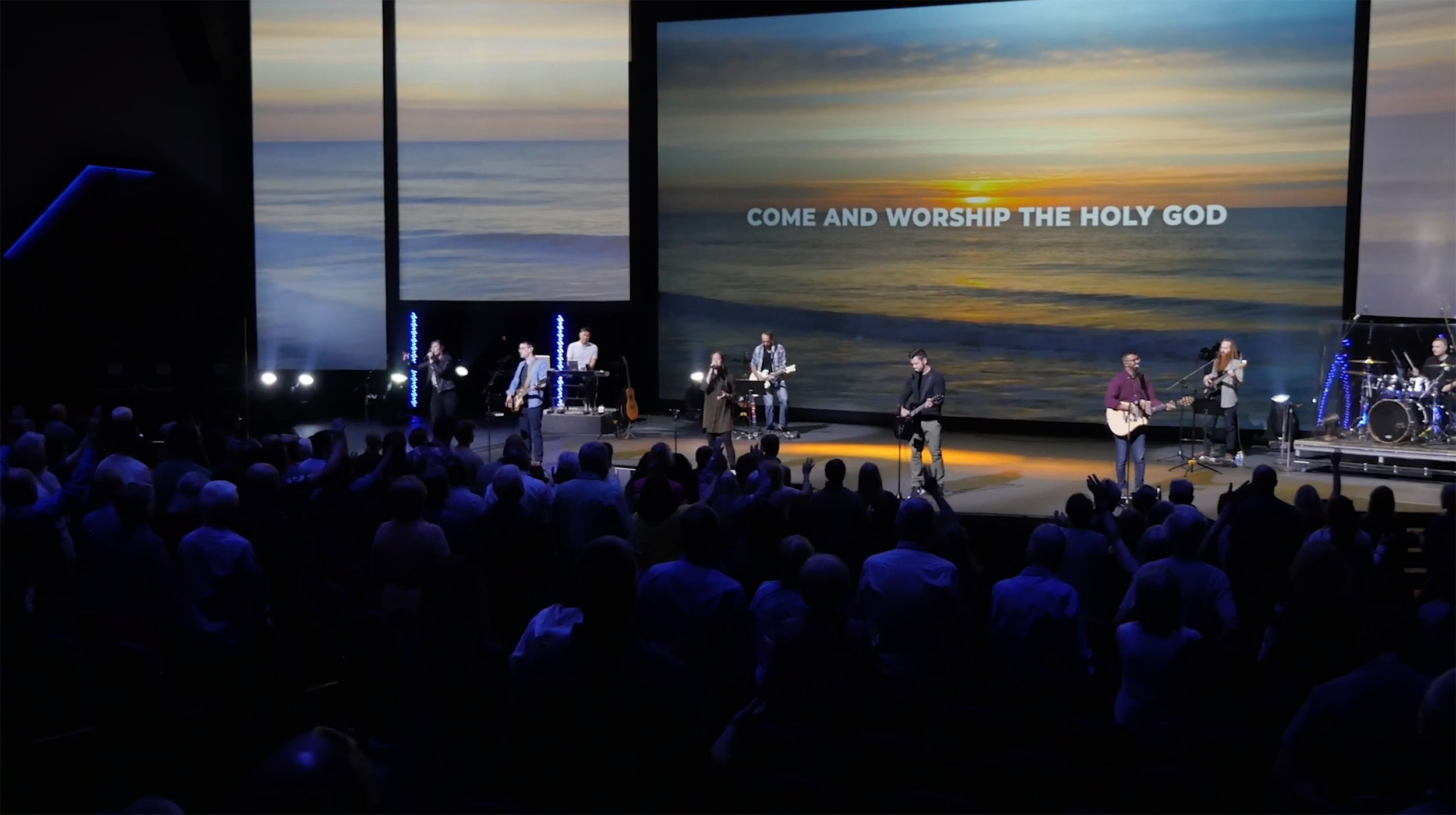 Worship band performing with sunset background.