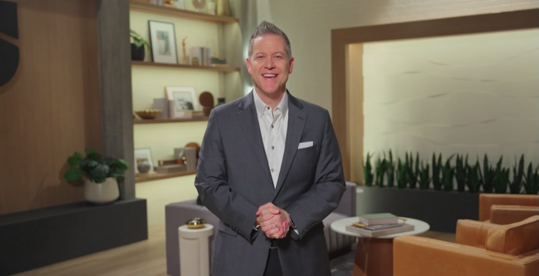 man in a sharp grey suit smiling