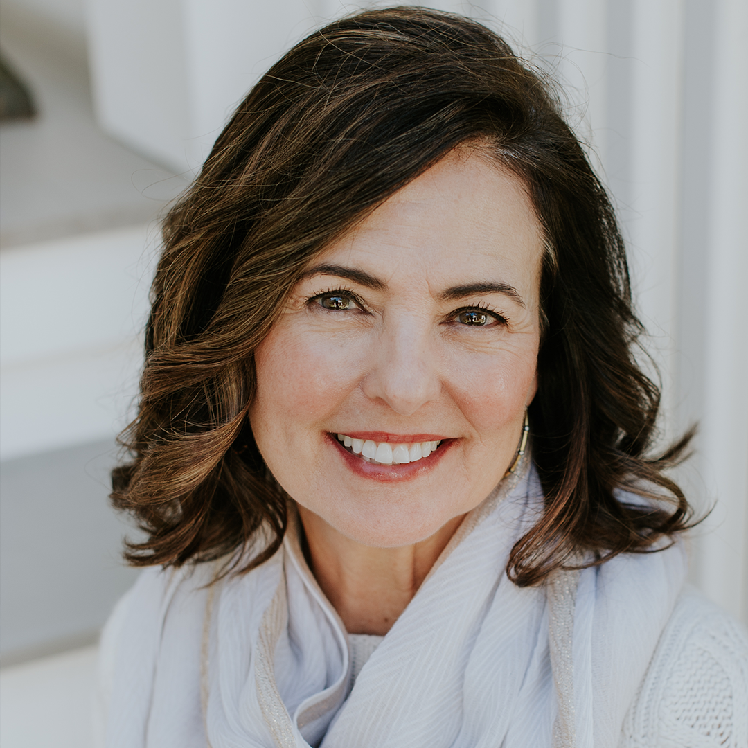 Smiling woman with shoulder-length hair and white top