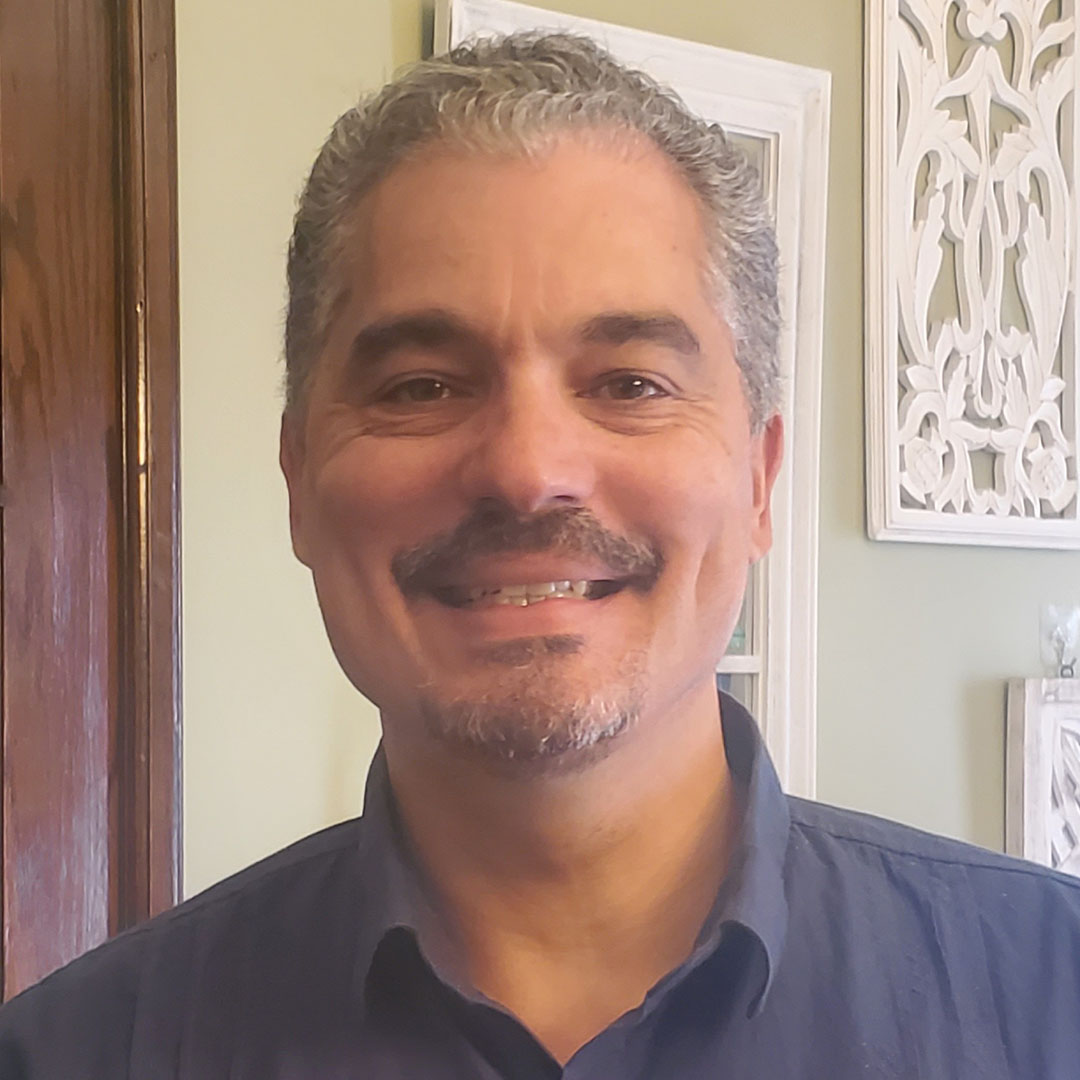 Smiling man with gray hair and mustache