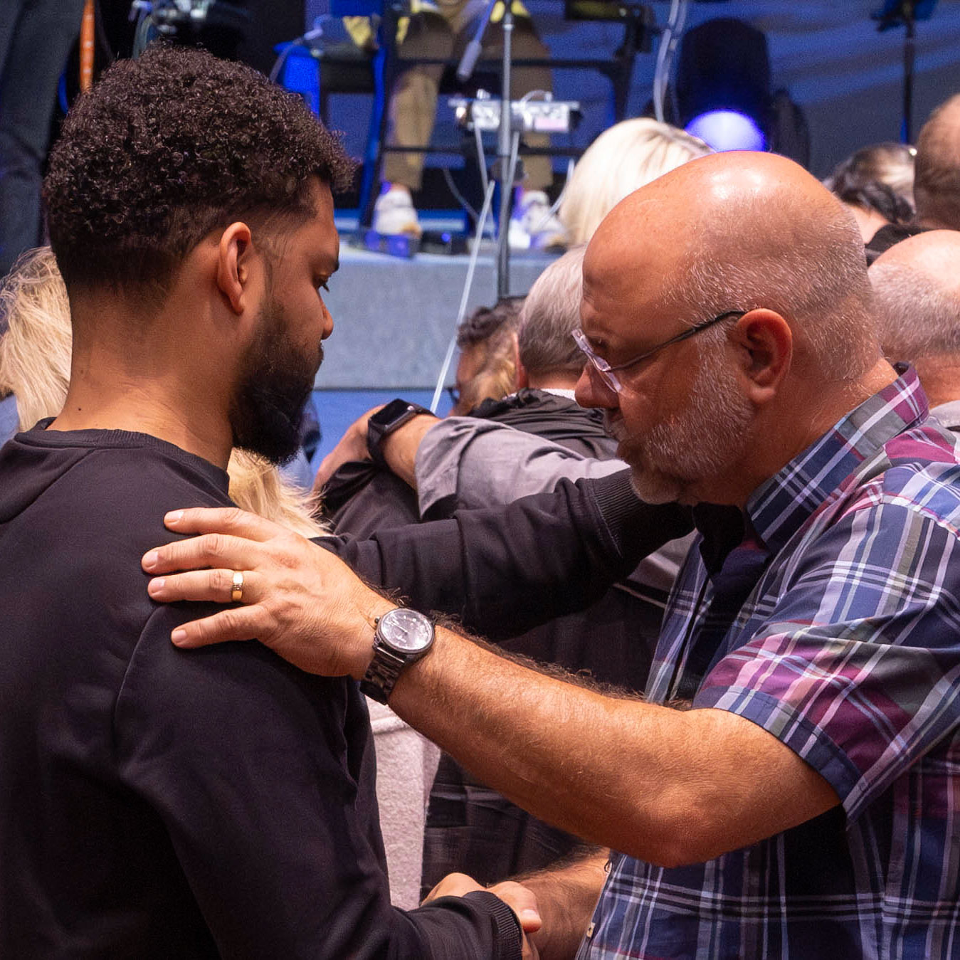 Two men embrace during a church service.