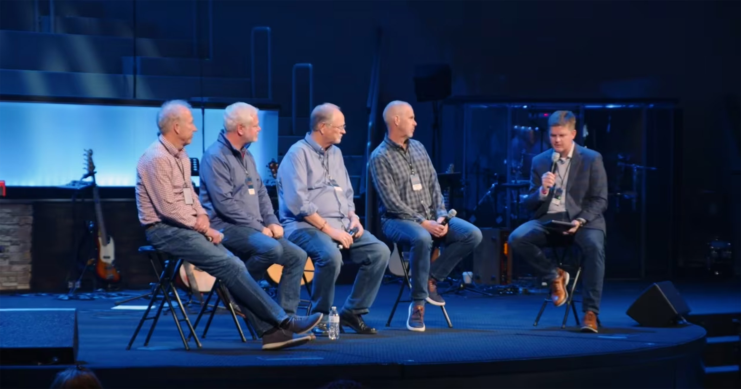 Panel discussion with five speakers on stage.