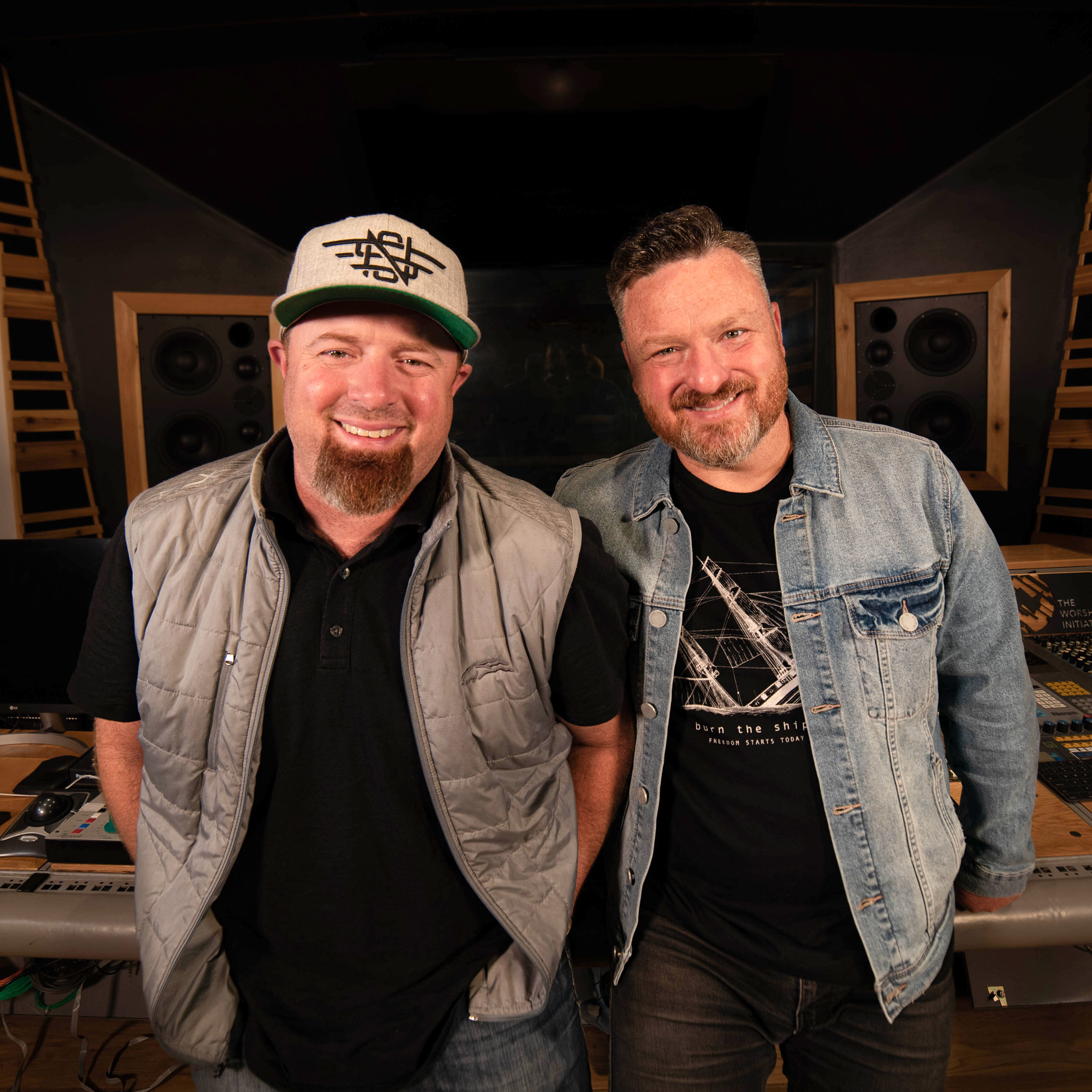 Two men smiling in a recording studio