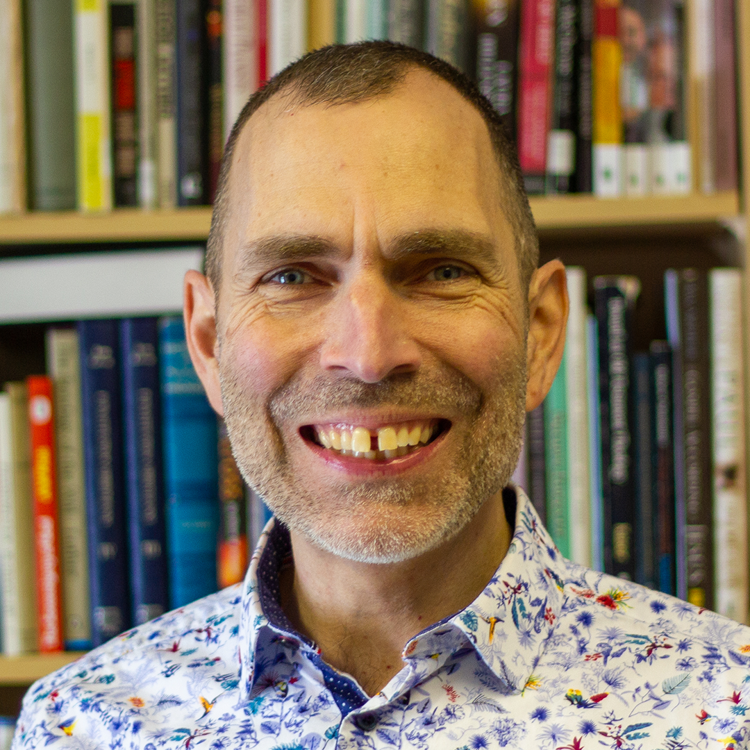 Smiling man in front of bookshelf