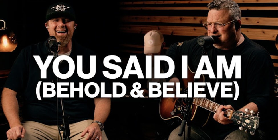 Two Men in Music studio in front of microphones, one with a guitar